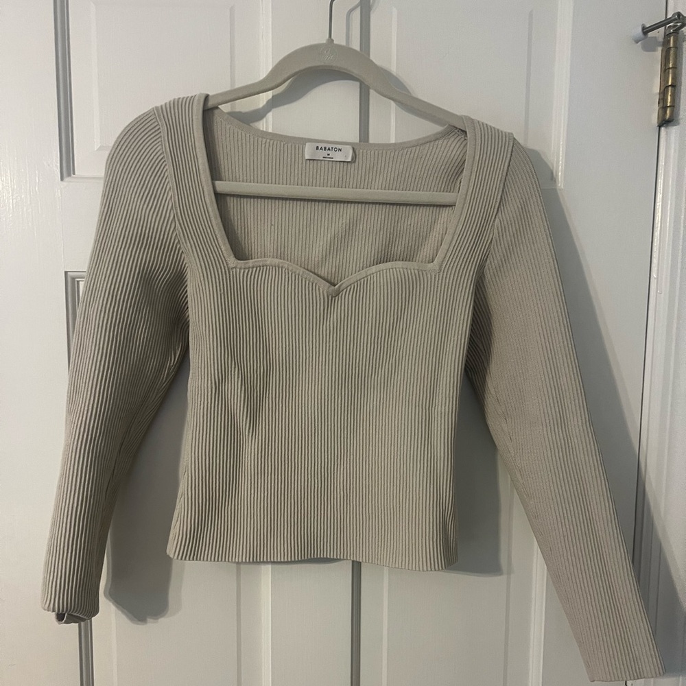 Beige compression type top. Slightly cropped and hits just above hips.